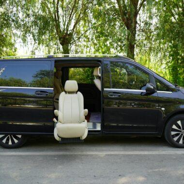 A luxurious black van with an elegant leather seat exposed outdoors, highlighting accessibility and comfort.